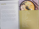 cookbook interior pages featuring a table of contents for soup recipes, as well as a picture of a bowl of soup.