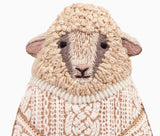 Textured sheep-shaped object with a knitted pattern on a white background.