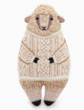 Stuffed sheep toy wearing a knitted sweater on a white background.