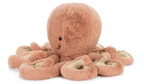 Plush peach colored octopus toy with a smiling face.