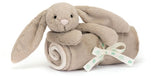Plush beige bunny toy with a blanket wrapped around it.