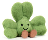 Green plush shamrock with a smiling face and brown legs.