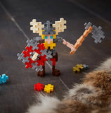 Toy figure of a warrior with shield and axe made from interlocking bricks.