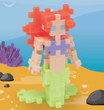 Mermaid toy figure made of interlocking bricks on a beach background.