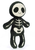 Skeleton plush toy with black and white design and a smiling face.