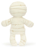 Plush white mummy toy with black eyes and a smiling face.