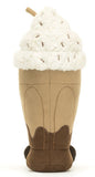 Plush toy resembling a chocolate milkshake with whipped cream and a cherry on top. It has a smiling face and brown corduroy legs.