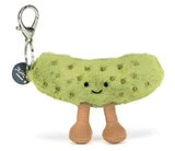 Plush green pickle bag charm with a smiling face and brown legs with a silver back clip.