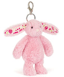 Pink plush bunny keychain with floral patterns on ears on a white background.