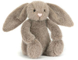 Plush brown toy rabbit with a white belly on a white background.