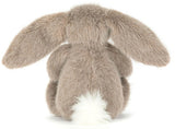 Plush brown toy rabbit with a white belly on a white background.