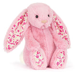 Pink plush bunny with floral ears on a white background.