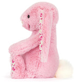 Pink plush bunny with floral ears on a white background.