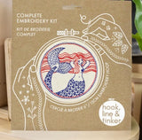 Complete embroidery kit packaging with mermaid design and 'hook, line & tinker' branding.
