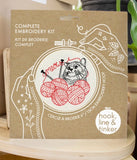 Embroidery kit packaging with a cat and yarn ball illustration and text.