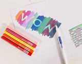 Colorful markers and a piece of paper with 'WOW' written on it.