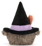 Gray plush toy owl wearing a large black witch hat with an orange feather tucked into the purple hatband.