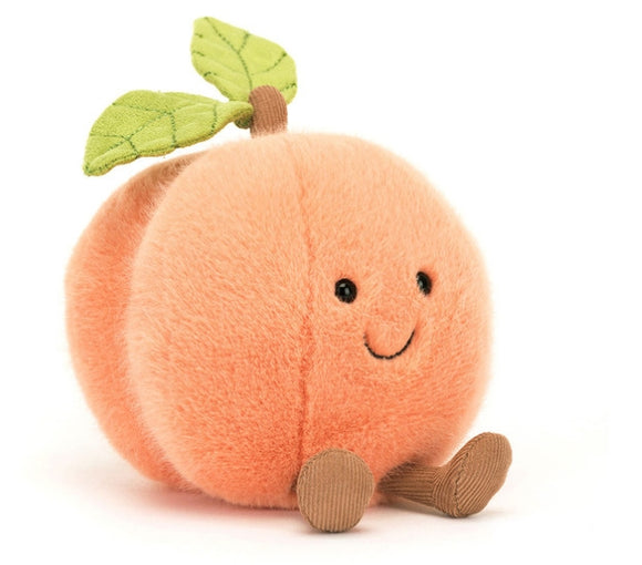 Plush toy peach with a brown stem and two leaves. It has a smiling face and brown corduroy legs.