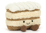 Stuffed toy resembling a beige layered cake with a smiling face.