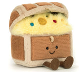 Plush toy resembling a brown and beige treasure chest with a smiling face and brown feet.