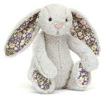 Gray plush bunny toy with large floppy ears, with floral fabric on ears and feet.